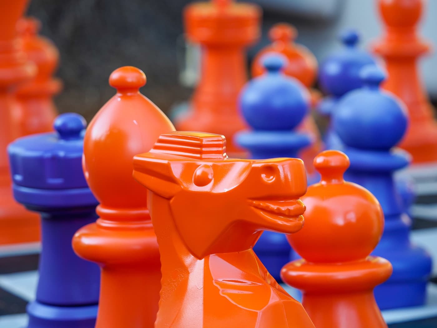 Giant orange and blue chess pieces, a knight in front